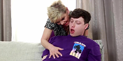 Older blonde woman gives a handjob to a younger fella