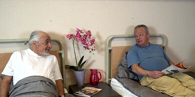 Brunette nurse blows an old dude as his friends looks on