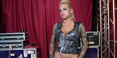 A blonde that has hot tattoos on her body is bending over for humping