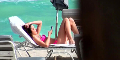 Beautiful and sexy dark-haired minx rests on the beach