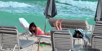 Beautiful and sexy dark-haired minx rests on the beach