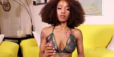 Fuzzy-haired black girl in bra gives a handjob using a sex toy