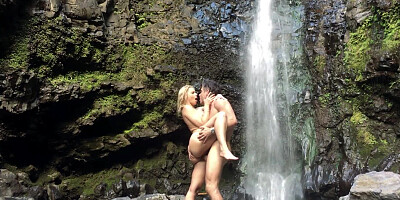 A blonde is getting penetrated by the waterfall outside on the clifs