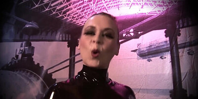 Dominatrix dressed in latex is playing with a toy