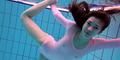 Nimble dame, Roxalana Cheh is dressed in a sheer costume while toying in the swimming pool