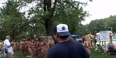A crowd of nude babes posing for photo-shoot outdoors