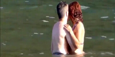 Horny couple having some fun in the water at the beach