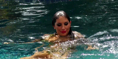 August Ames frolics in a swimming pool with her huge curves