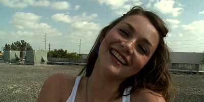 Brunette is naked on the roof, spreading her pussy lips to a guy