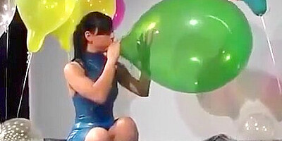 Sexy Girl In Latex Dress Blows to Pop Some Big Balloons
