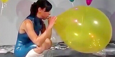 Sexy Girl In Latex Dress Blows to Pop Some Big Balloons