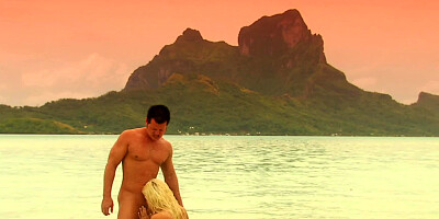 A blonde is by the ocean with her lover and she is kissing him there
