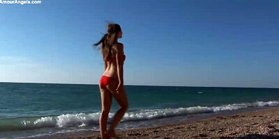 Fabulous honey in a crimson bathing suit got bare on the beach, while no one was eyeing her