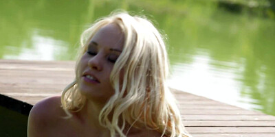Blonde solo girl is fooling around in the lake in a boat, naked