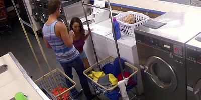A couple is having fun in the laundromat while they are alone