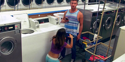 A couple is having fun in the laundromat while they are alone