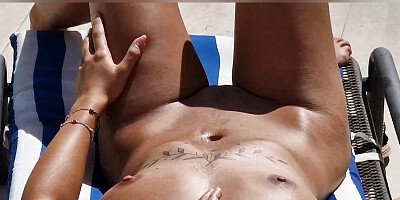 naked woman on a lounger by the hotel pool