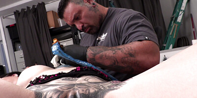 Marie Bossette plays with her toy while being tattooed