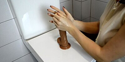 SECRETARY IN STOCKINGS RIDES HER DILDO IN TOILET
