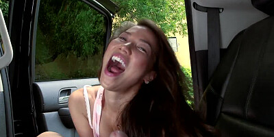 A brunette is in the car, and she is pulling on a really large pole