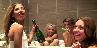 Naked champagne drinking friends look good in the bathtub