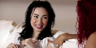 Ebony and white girls tease each other on the white couch