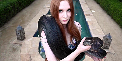 Redhead snake charmer poses nude outdoor
