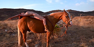 Red babe reveals her pussy on horseback