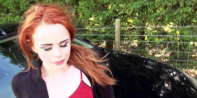 A redhead is outside and she is taking care of a dick