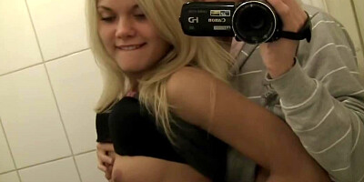 A chick is getting undressed in a public restroom in a restaurant