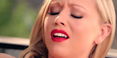 A blonde is on the hood of the car, playing with wet pussy lips