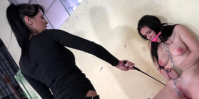 Submissive girl is tied up and flogged by a mistress