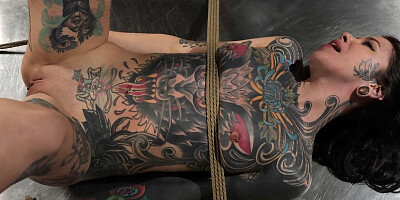 Tattooed girl is bound and fingered in BDSM dungeon
