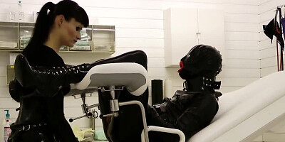 Perverted mistress is playing with tied-up gimp's cock and balls