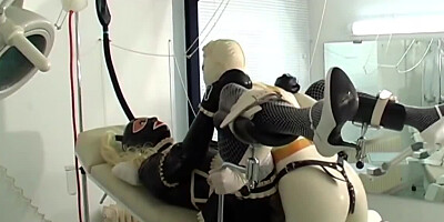One girl is bound in latex as the other one strap-on fucks her