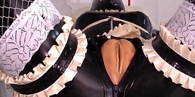 One girl is bound in latex as the other one strap-on fucks her