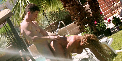 A blonde with huge fake boobs is outdoors and she is sitting on dick