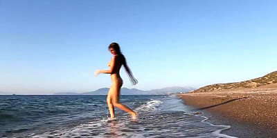 Young beauty Maria Tara caresses herself on the beach