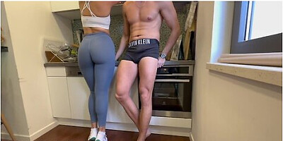 Couple grinds together after gym session in kitchen