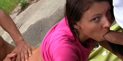 A brunette that has a nice body is giving a blow job to two men