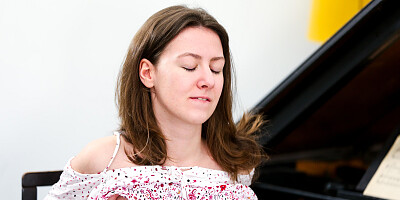 Shy brunette strips and fingers herself beside grand piano