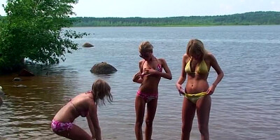 Several girls are getting naked at the beach in a hot scene
