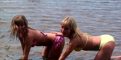 Several girls are getting naked at the beach in a hot scene
