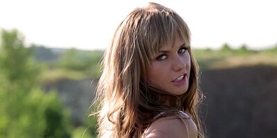 A thin woman shakes her ass while she is outside in nature