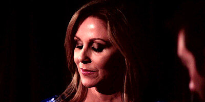 A blonde is having a romantic dinner with her lover in the dark