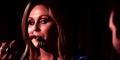 A blonde is having a romantic dinner with her lover in the dark