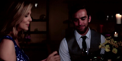 A blonde is having a romantic dinner with her lover in the dark