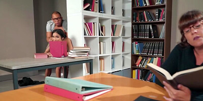 Young black man and Asian want each other in the library