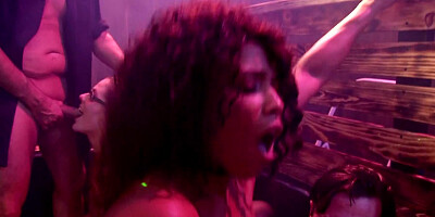 Several girls are with some guys in a seedy club, fucking around