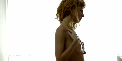 A curly blonde is on the bed, getting her pussy fucked really well